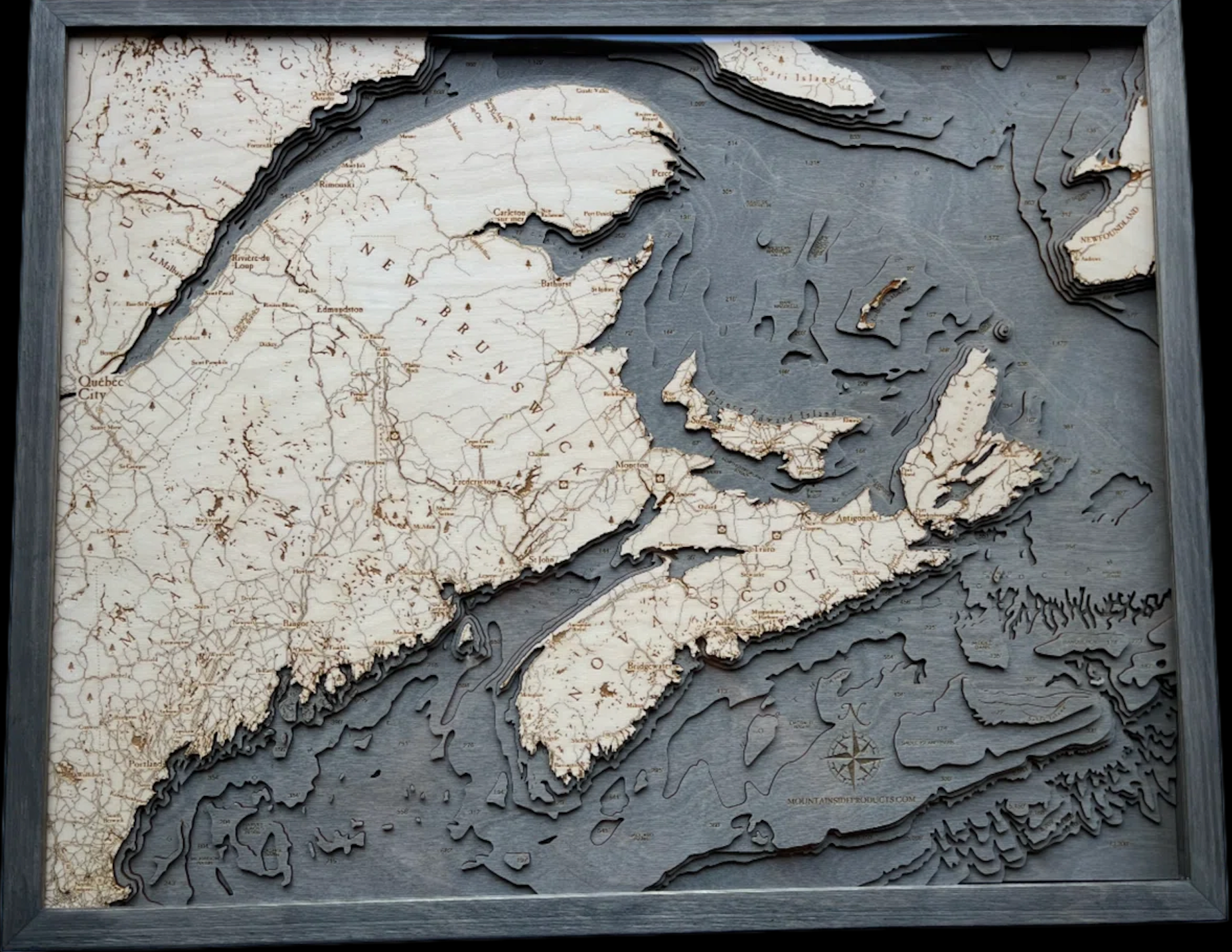 Canadian Maritimes 3D layered wood map in laser-cut Baltic birch, shown framed against a light wall