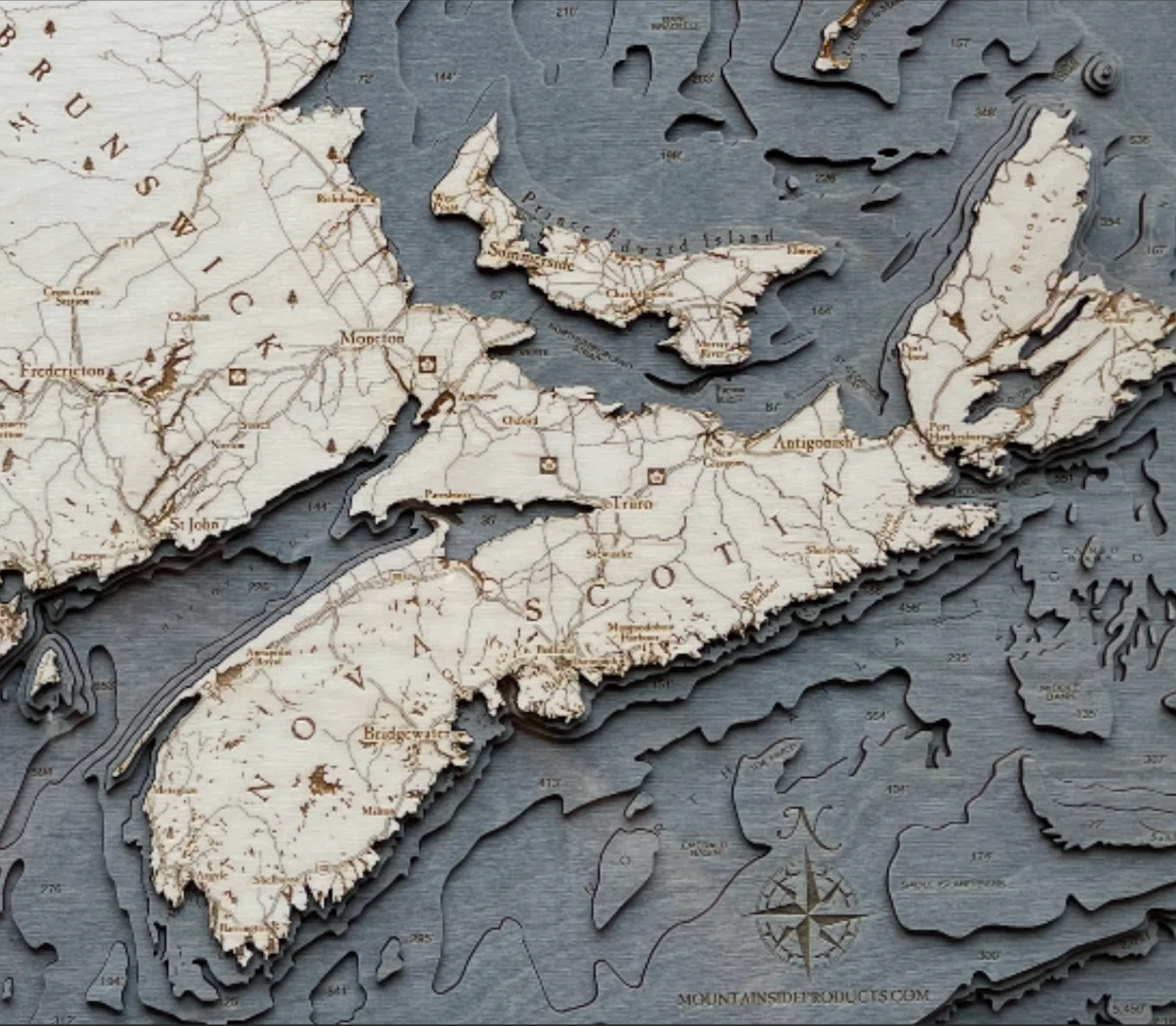 Canadian Maritimes 3D layered wood map in laser-cut Baltic birch, shown framed against a light wall