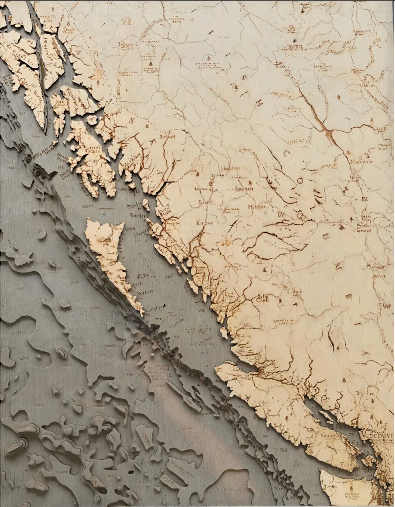 British Columbia Coast 3D layered wood map in laser-cut Baltic birch, shown framed against a light wall