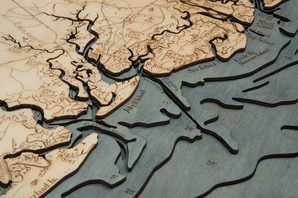 Georgia Coast 3D layered wood map in laser-cut Baltic birch, shown framed against a light wall