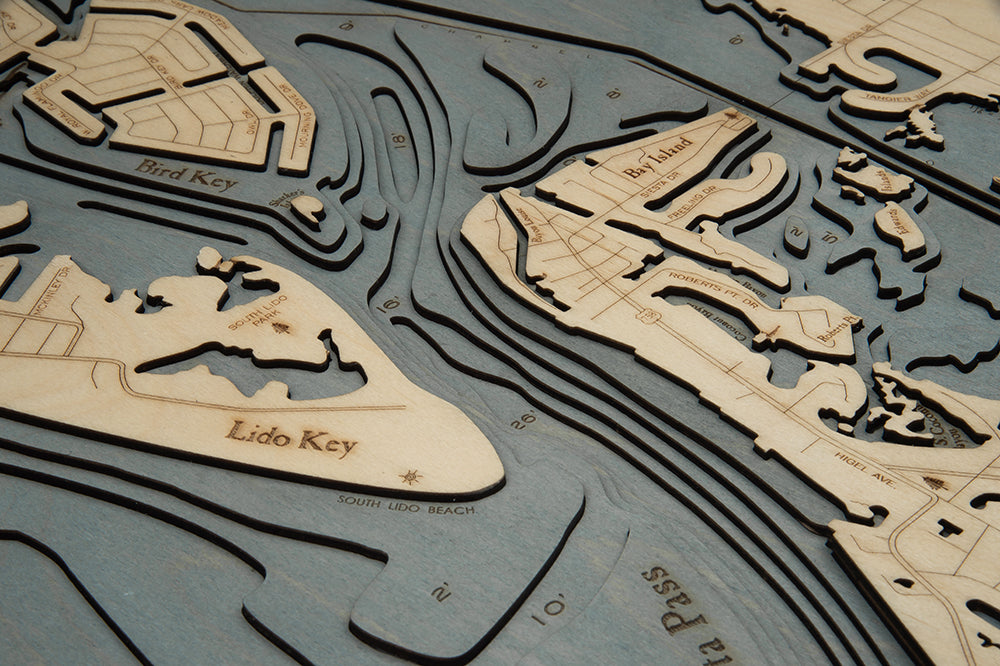 Siesta Key, Florida 3D layered wood map in laser-cut Baltic birch, shown framed against a light wall