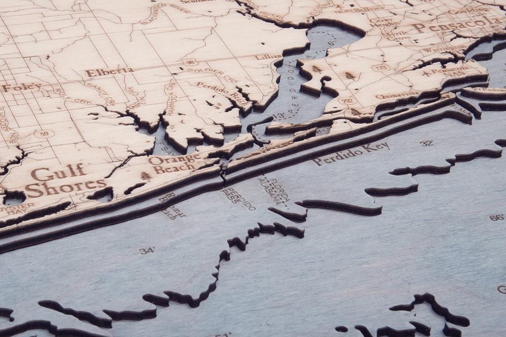 Western Panhandle, Florida 3D layered wood map in laser-cut Baltic birch, shown framed against a light wall