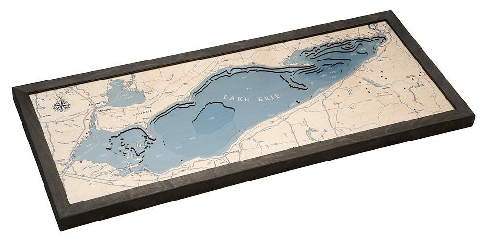 Lake Erie 3D layered wood map in laser-cut Baltic birch, shown framed against a light wall