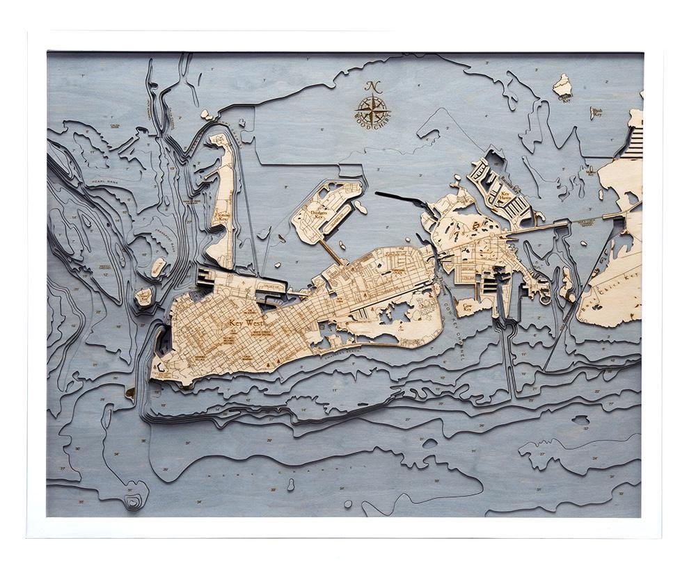 Key West, Florida 3D layered wood map in laser-cut Baltic birch, shown framed against a light wall