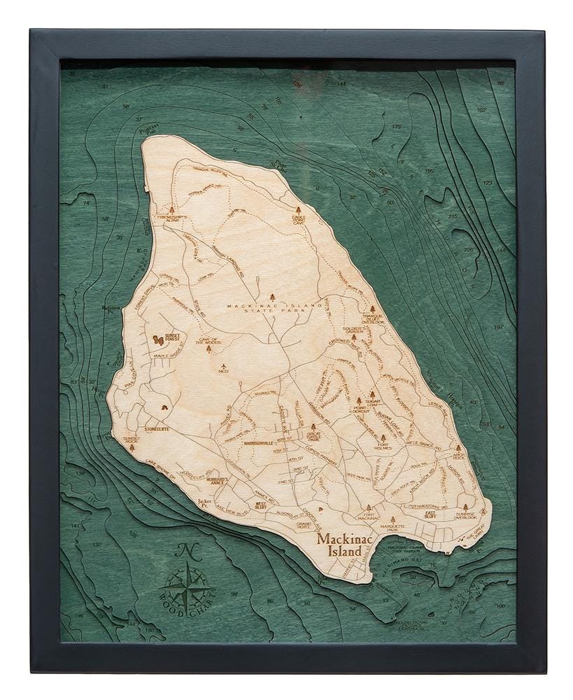 Mackinac Island, Michigan 3D layered wood map in laser-cut Baltic birch, shown framed against a light wall