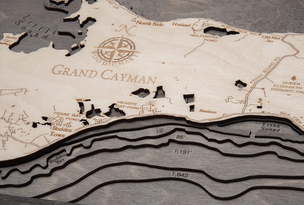 Grand Cayman, Caribbean 3D layered wood map in laser-cut Baltic birch, shown framed against a light wall