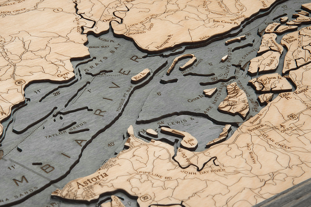 Columbia River Mouth, Oregon 3D layered wood map in laser-cut Baltic birch, shown framed against a light wall