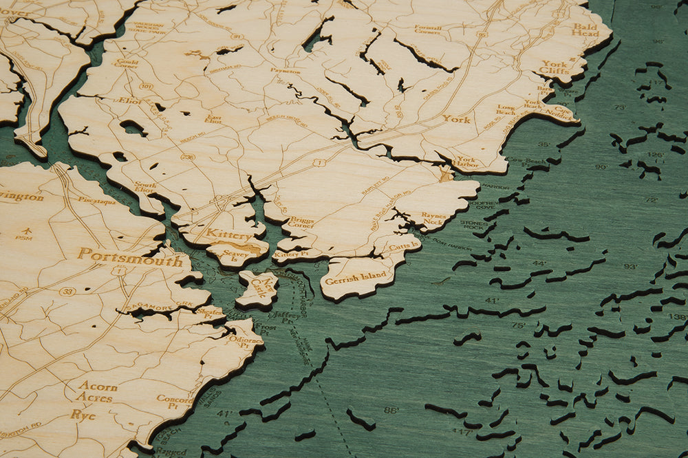 New Hampshire Coast 3D layered wood map in laser-cut Baltic birch, shown framed against a light wall