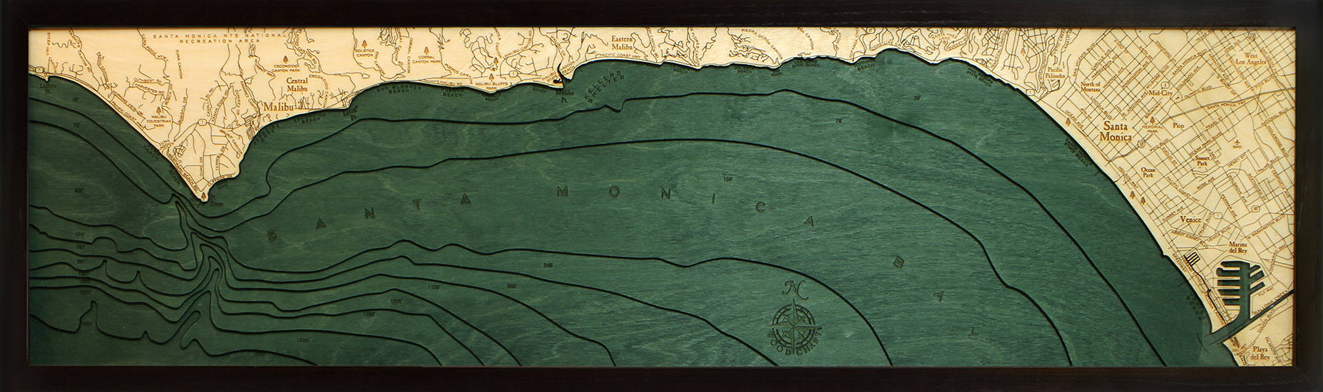 Malibu, California 3D layered wood map in laser-cut Baltic birch, shown framed against a light wall