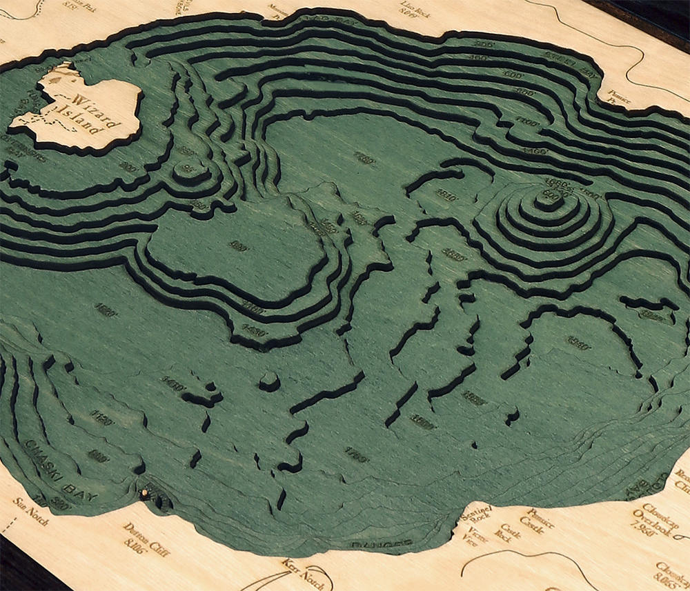 Crater Lake, Oregon 3D layered wood map in laser-cut Baltic birch, shown framed against a light wall