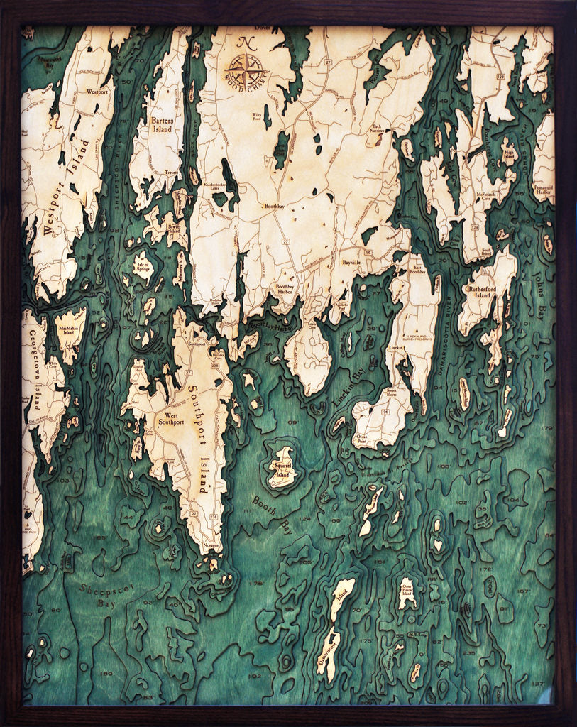 Boothbay Harbor, Maine 3D layered wood map in laser-cut Baltic birch, shown framed against a light wall
