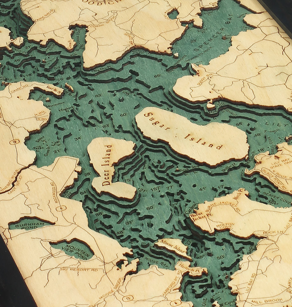Moosehead Lake, Maine 3D layered wood map in laser-cut Baltic birch, shown framed against a light wall