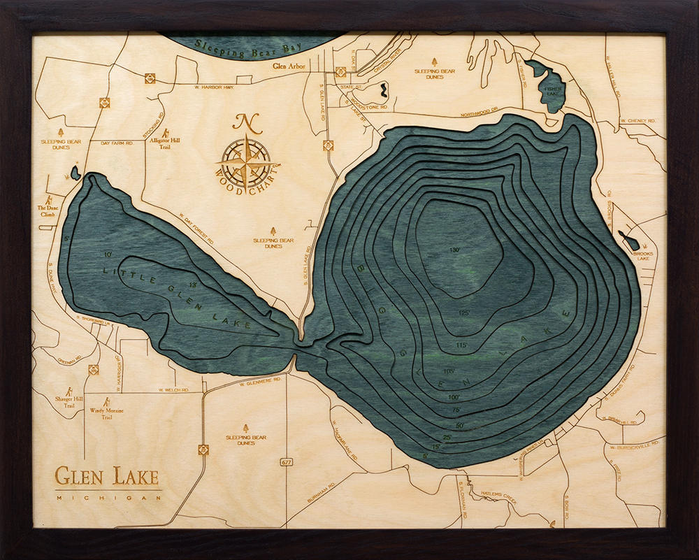 Glen Lake, Michigan 3D layered wood map in laser-cut Baltic birch, shown framed against a light wall