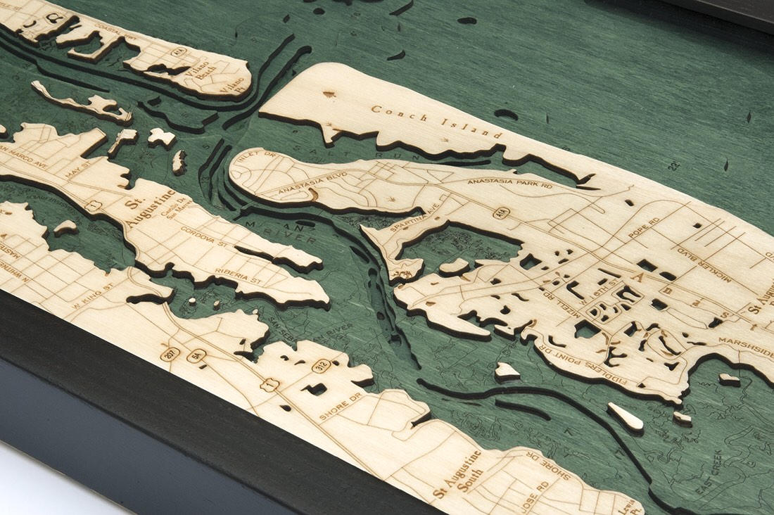 Saint Augustine, Florida 3D layered wood map in laser-cut Baltic birch, shown framed against a light wall