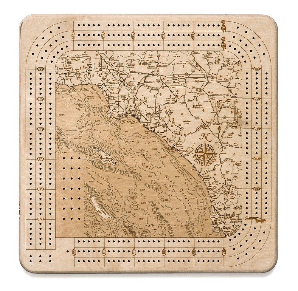 LA to San Diego, California wood cribbage board in laser-cut Baltic birch, shown framed against a light wall