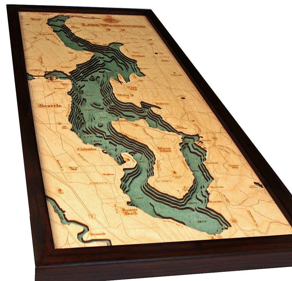 Lake Washington 3D layered wood map in laser-cut Baltic birch, shown framed against a light wall
