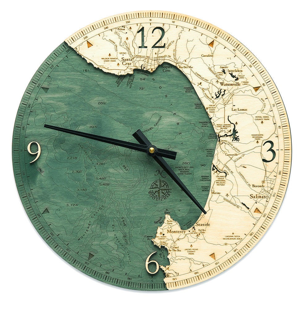 Monterey Bay, California wood wall clock in laser-cut Baltic birch, shown framed against a light wall