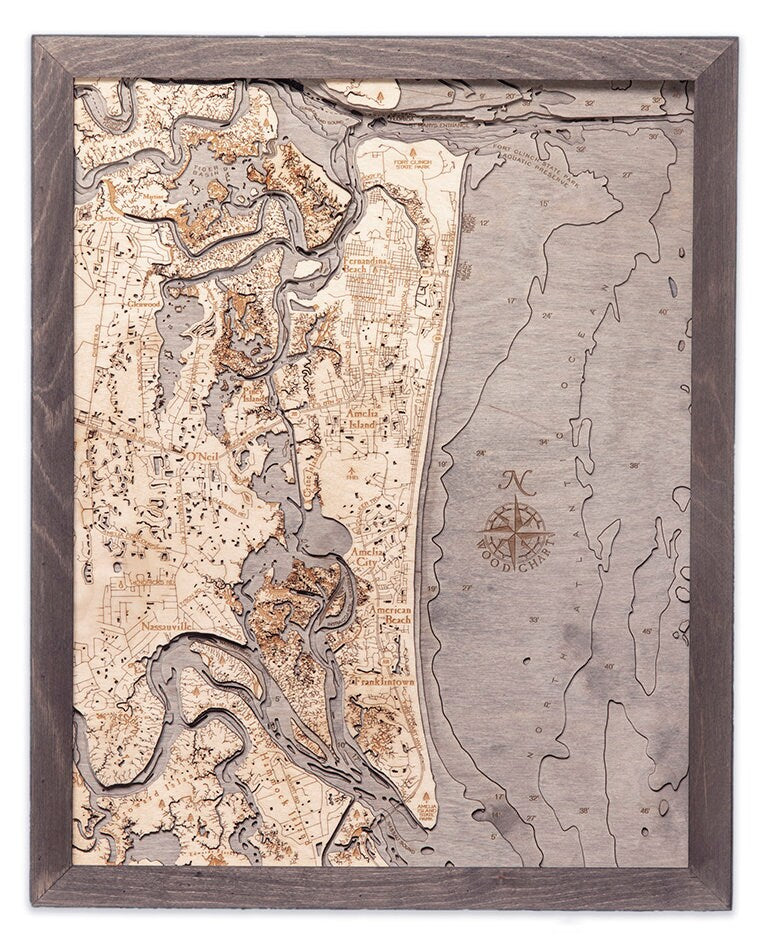 Amelia Island, Florida 3D layered wood map in laser-cut Baltic birch, shown framed against a light wall