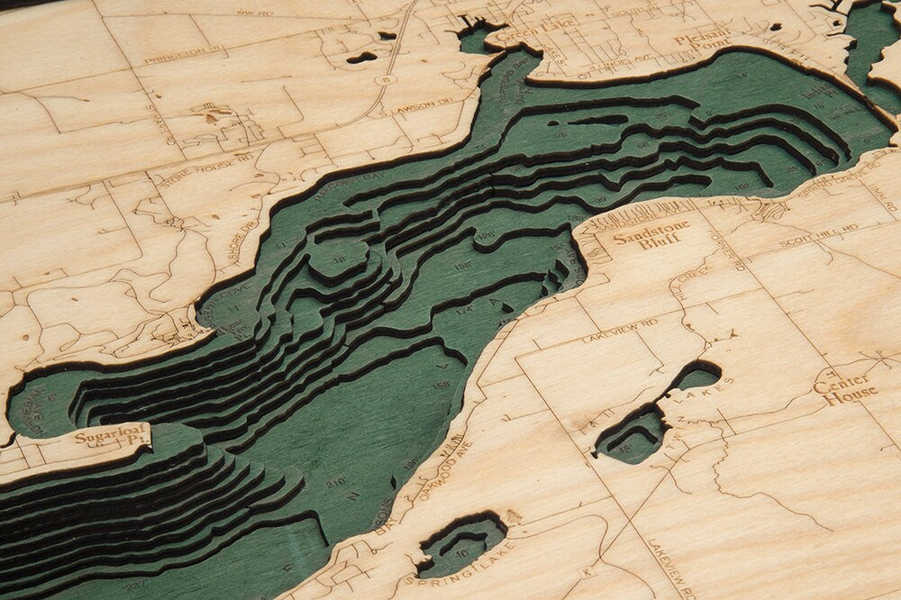 Green Lake, Wisconsin 3D layered wood map in laser-cut Baltic birch, shown framed against a light wall