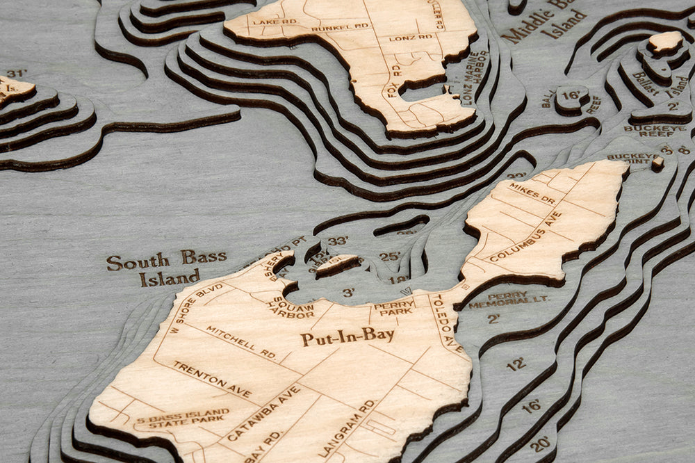 Put-in-Bay, Ohio 3D layered wood map in laser-cut Baltic birch, shown framed against a light wall