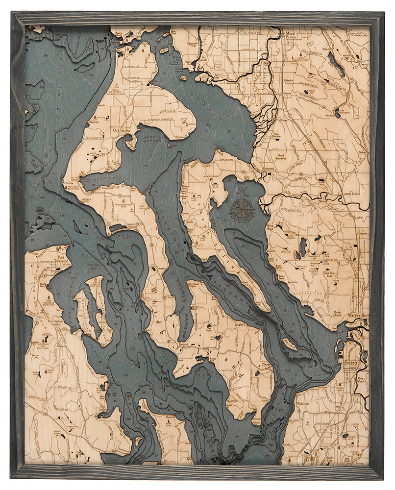 Whidbey & Camano Islands, Washington 3D layered wood map in laser-cut Baltic birch, shown framed against a light wall