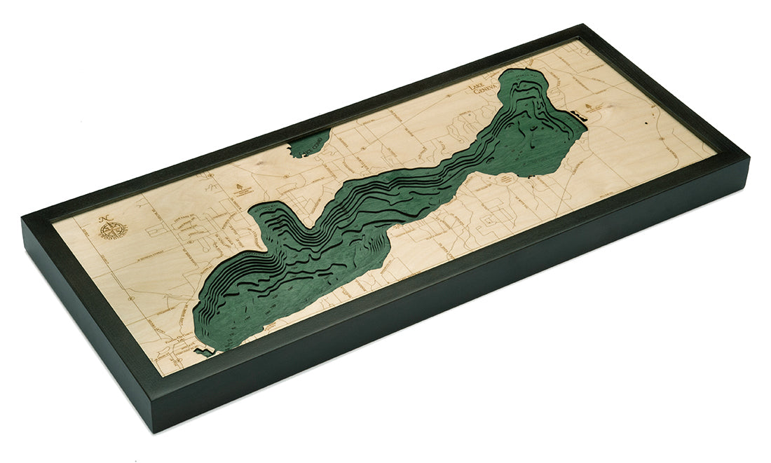 Lake Geneva, Wisconsin 3D layered wood map in laser-cut Baltic birch, shown framed against a light wall