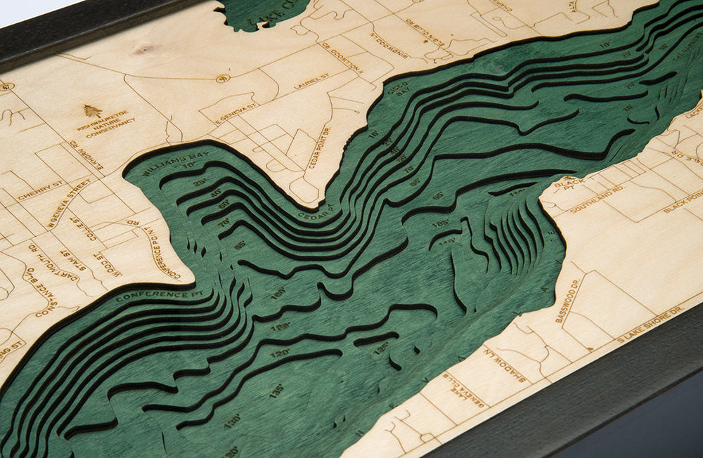 Lake Geneva, Wisconsin 3D layered wood map in laser-cut Baltic birch, shown framed against a light wall