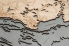 Delaware Bay 3D layered wood map in laser-cut Baltic birch, shown framed against a light wall