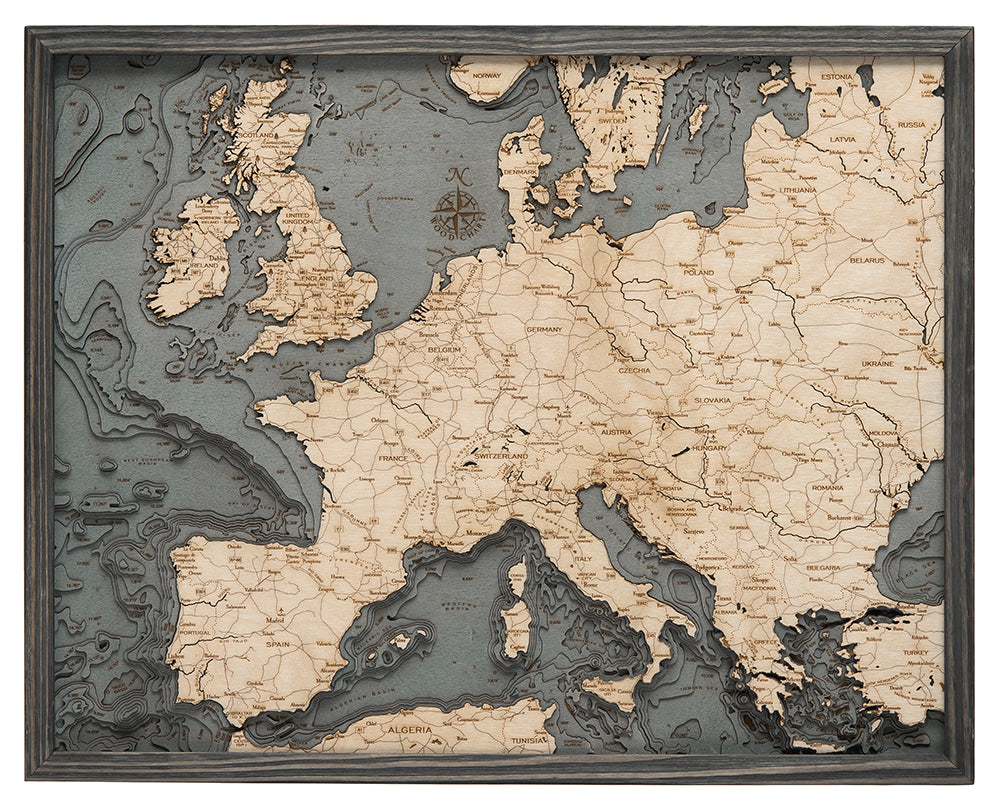 Western Europe 3D layered wood map in laser-cut Baltic birch, shown framed against a light wall