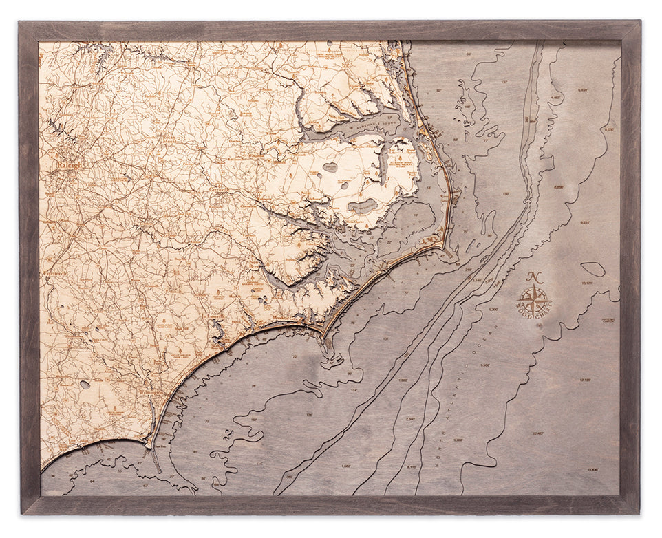 North Carolina Coast 3D layered wood map in laser-cut Baltic birch, shown framed against a light wall