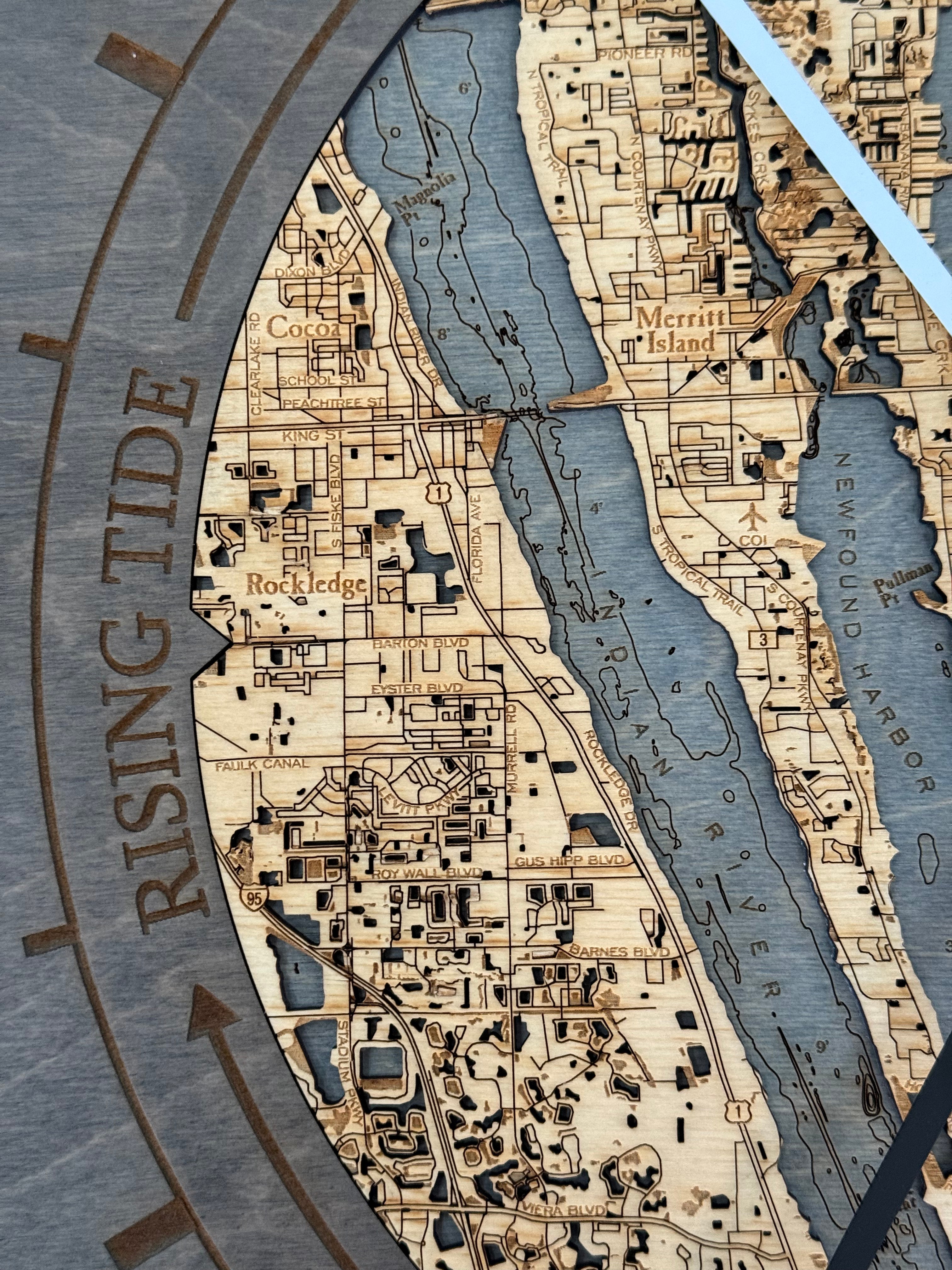 Cocoa Beach, Florida wood tide clock in laser-cut Baltic birch, shown framed against a light wall