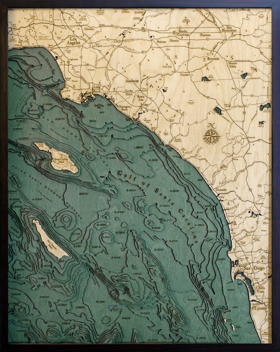 LA to San Diego, California 3D layered wood map in laser-cut Baltic birch, shown framed against a light wall