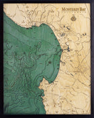 Monterey Bay, California 3D layered wood map in laser-cut Baltic birch, shown framed against a light wall