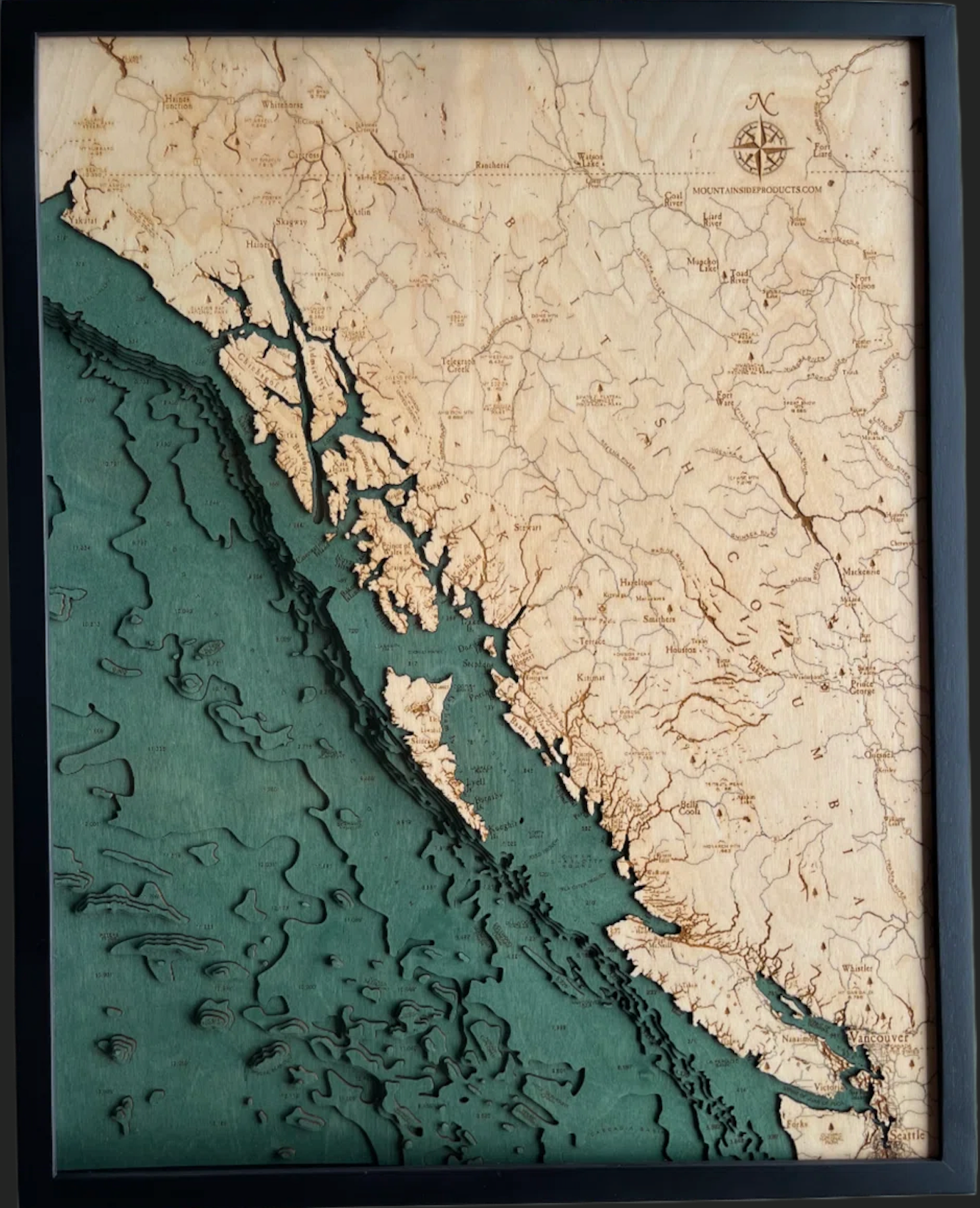 British Columbia Coast 3D layered wood map in laser-cut Baltic birch, shown framed against a light wall
