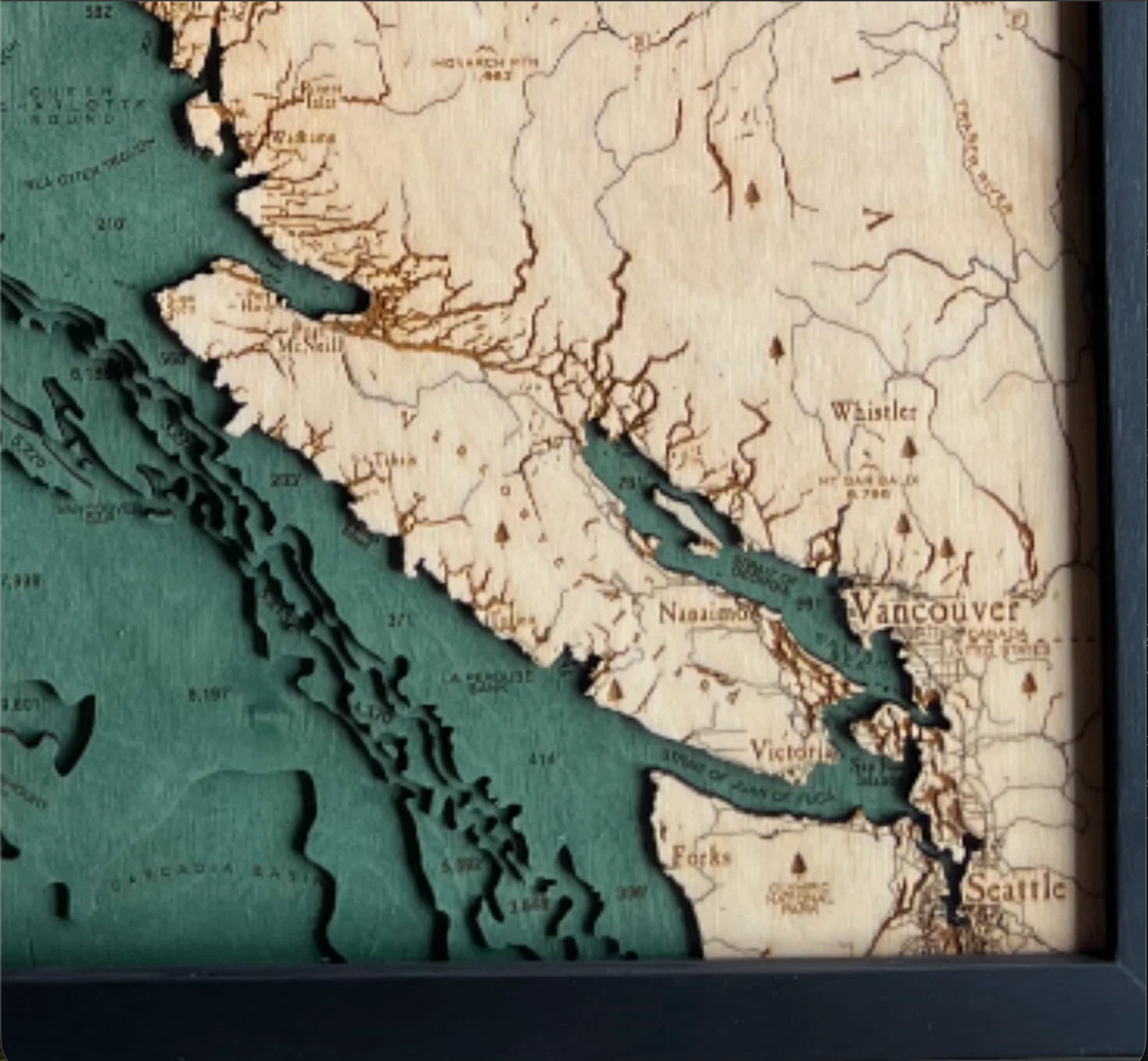 British Columbia Coast 3D layered wood map in laser-cut Baltic birch, shown framed against a light wall