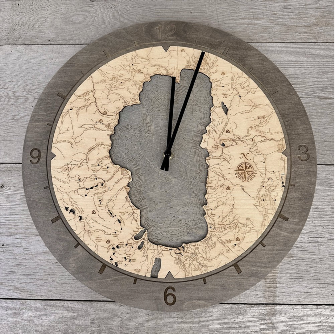 Lake Tahoe, California wood wall clock in laser-cut Baltic birch, shown framed against a light wall