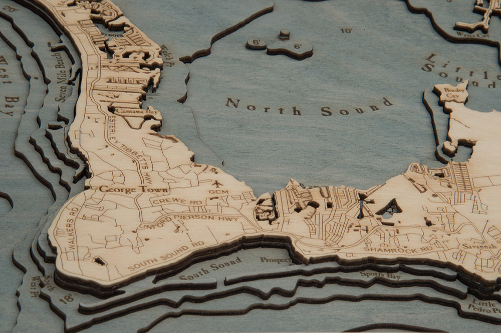 Grand Cayman, Caribbean 3D layered wood map in laser-cut Baltic birch, shown framed against a light wall
