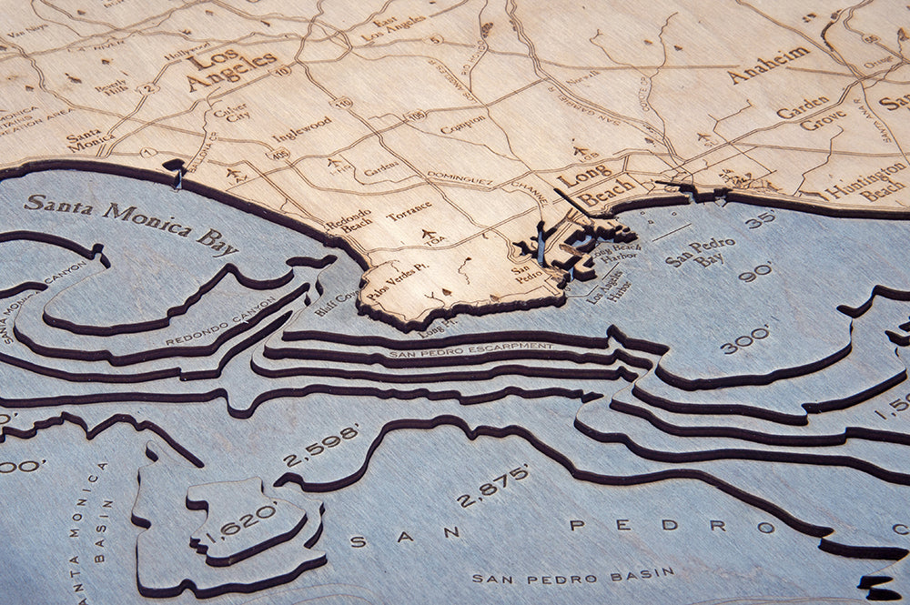 LA to San Diego, California 3D layered wood map in laser-cut Baltic birch, shown framed against a light wall