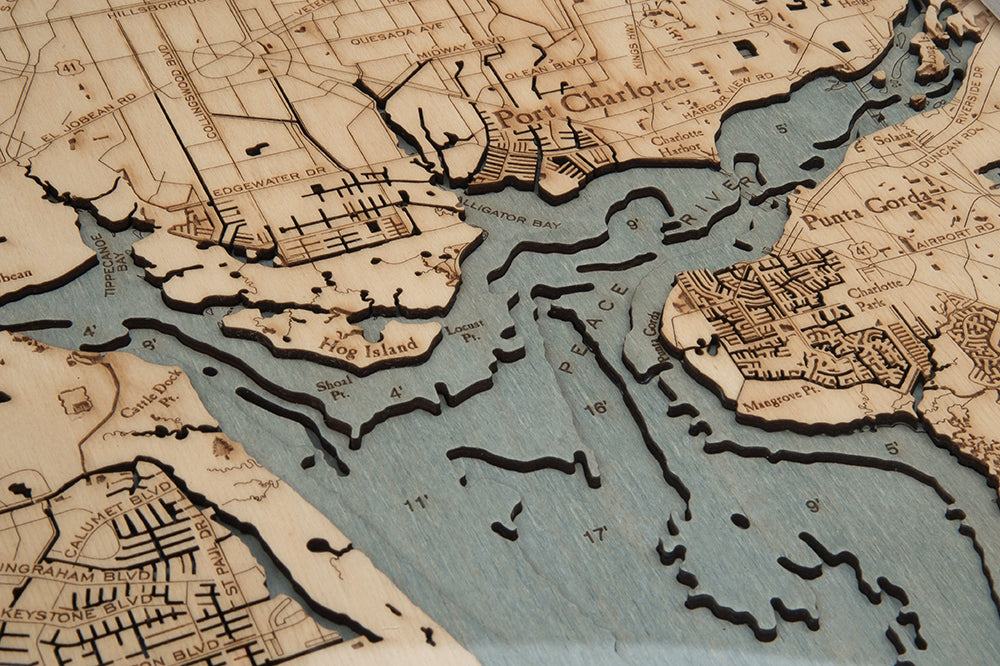 Charlotte Harbor, Florida 3D layered wood map in laser-cut Baltic birch, shown framed against a light wall
