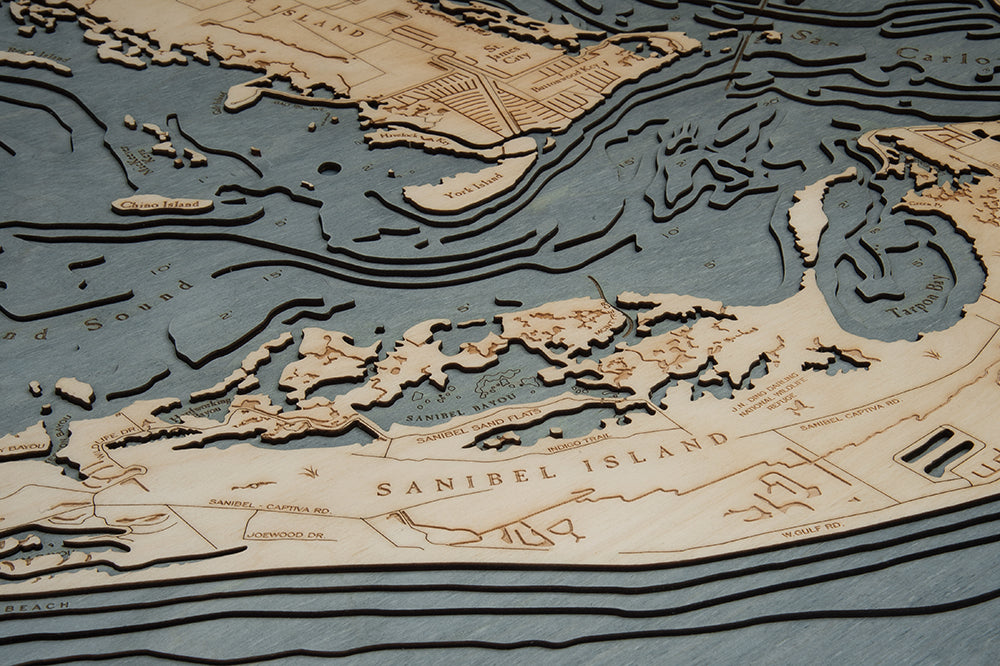 Sanibel Island, Florida 3D layered wood map in laser-cut Baltic birch, shown framed against a light wall