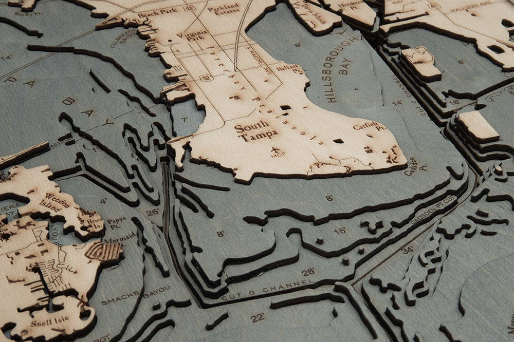 Tampa Bay, Florida 3D layered wood map in laser-cut Baltic birch, shown framed against a light wall