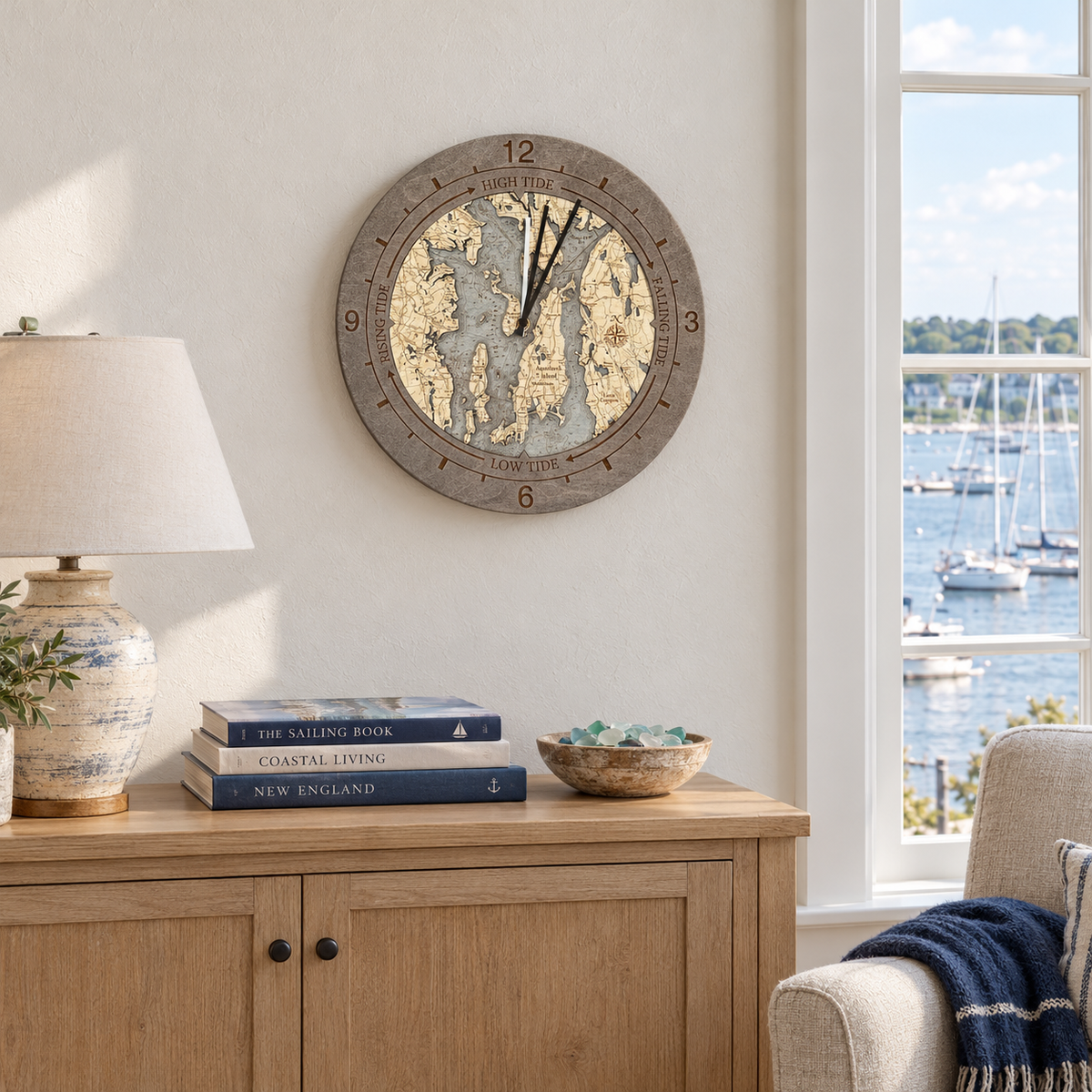 Narragansett Bay tide and time clock hanging above an oak sideboard in a coastal living room with sailboats outside the window