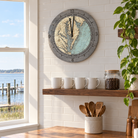 Chesapeake Bay tide and time clock hanging on a white tile kitchen wall above an open shelf of mugs, with a window looking out on the bay