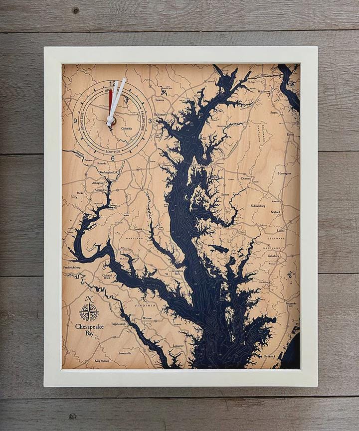 Chesapeake Bay, Maryland wood tide clock in laser-cut Baltic birch, shown framed against a light wall