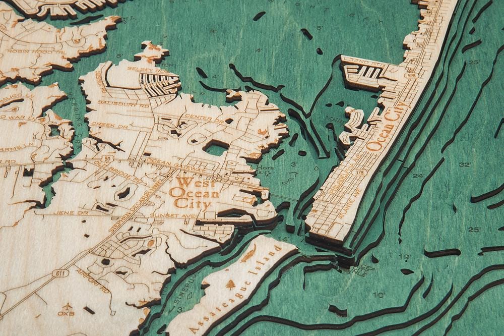 New Jersey Coast 3D layered wood map in laser-cut Baltic birch, shown framed against a light wall