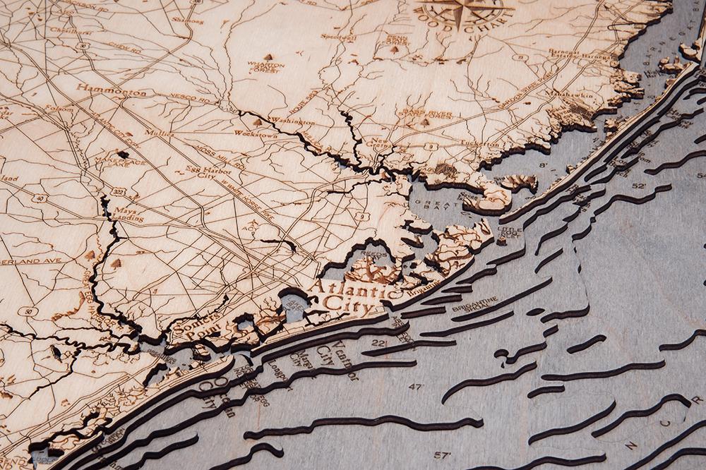 New Jersey Coast 3D layered wood map in laser-cut Baltic birch, shown framed against a light wall