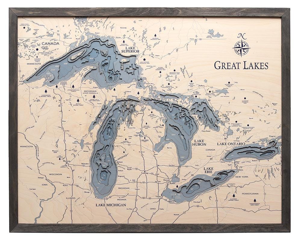Great Lakes 3D layered wood map in laser-cut Baltic birch, shown framed against a light wall
