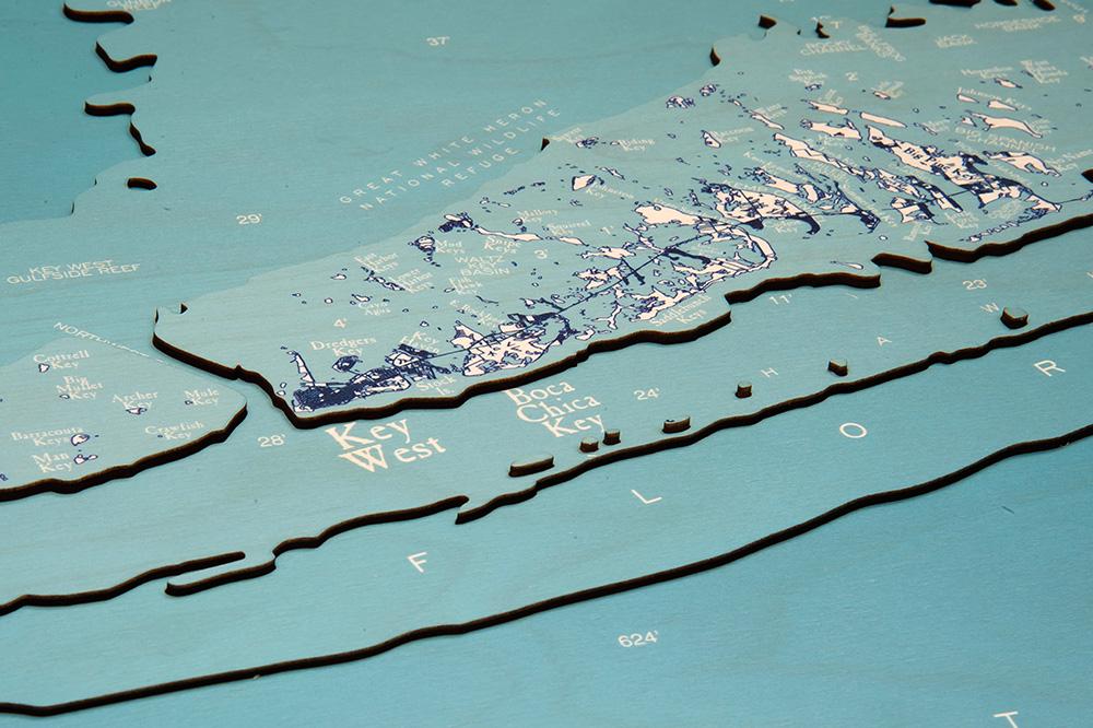 Florida Keys 3D layered wood map in laser-cut Baltic birch, shown framed against a light wall