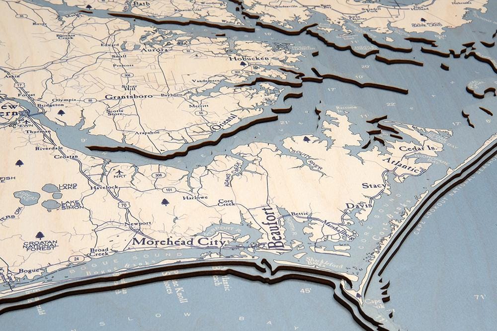 Outer Banks, North Carolina 3D layered wood map in laser-cut Baltic birch, shown framed against a light wall