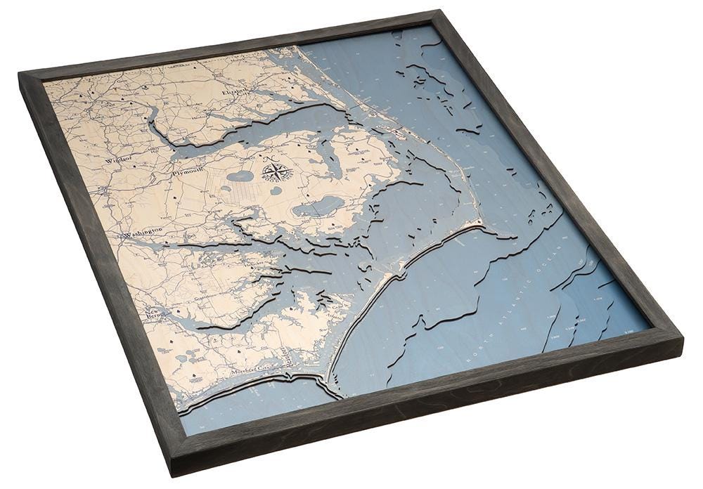 Outer Banks, North Carolina 3D layered wood map in laser-cut Baltic birch, shown framed against a light wall